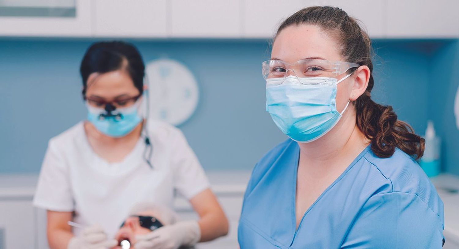 Smiling dental practitioner in mask