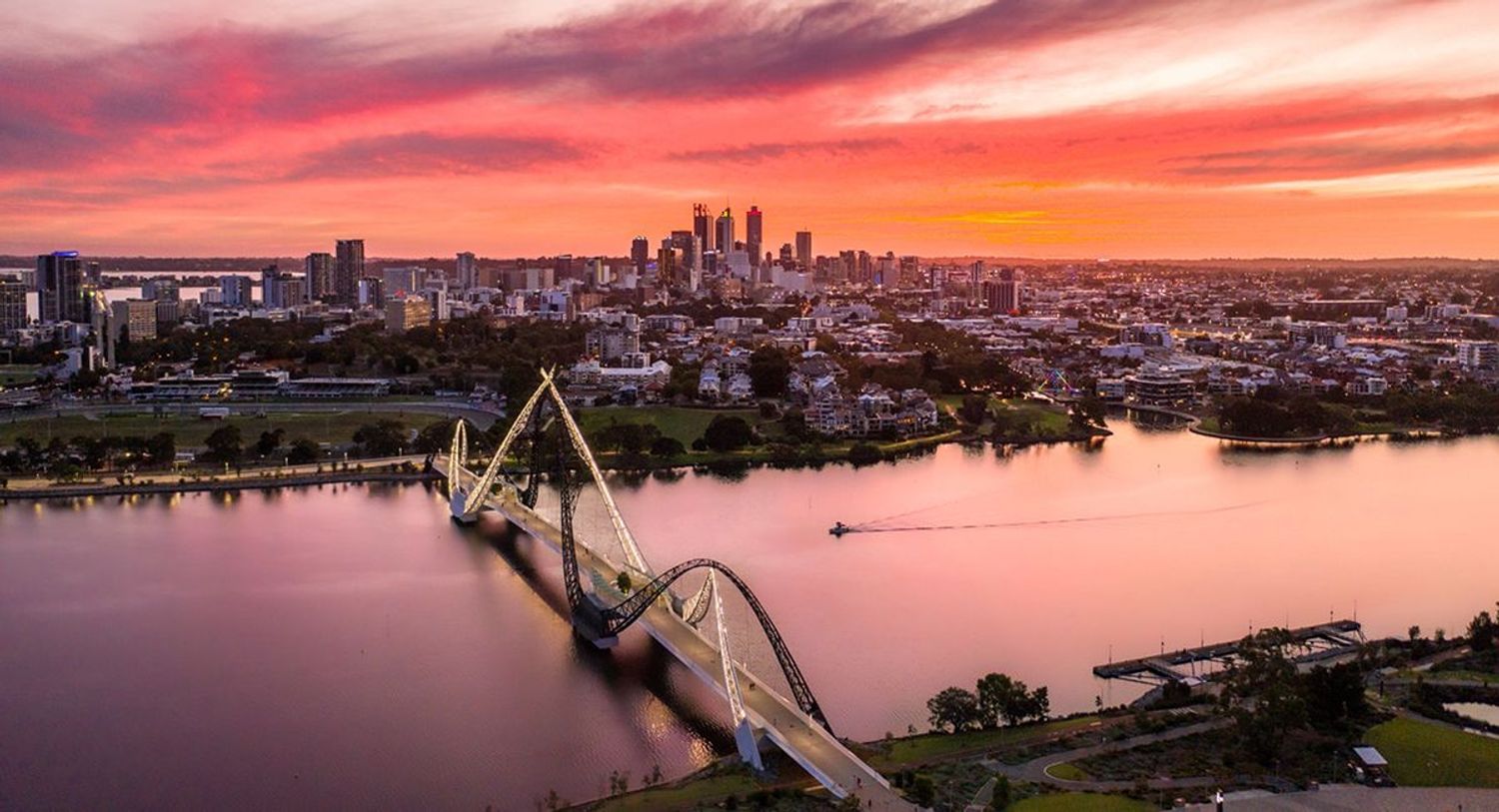 An aerial shot of Perth at sunset showing the city bathed in beautiful red, oranges and golds