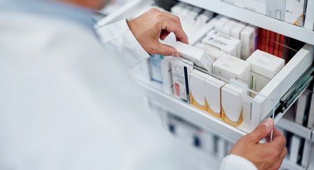 A pharmacist flicking through a draw full of medicines