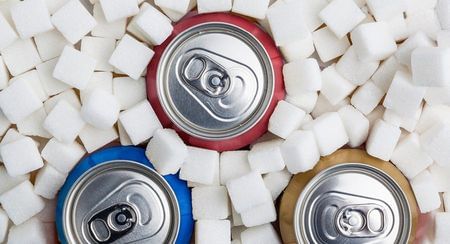 Three soft drink cans in sugar cubes