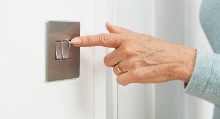 A hand flicking up a light switch