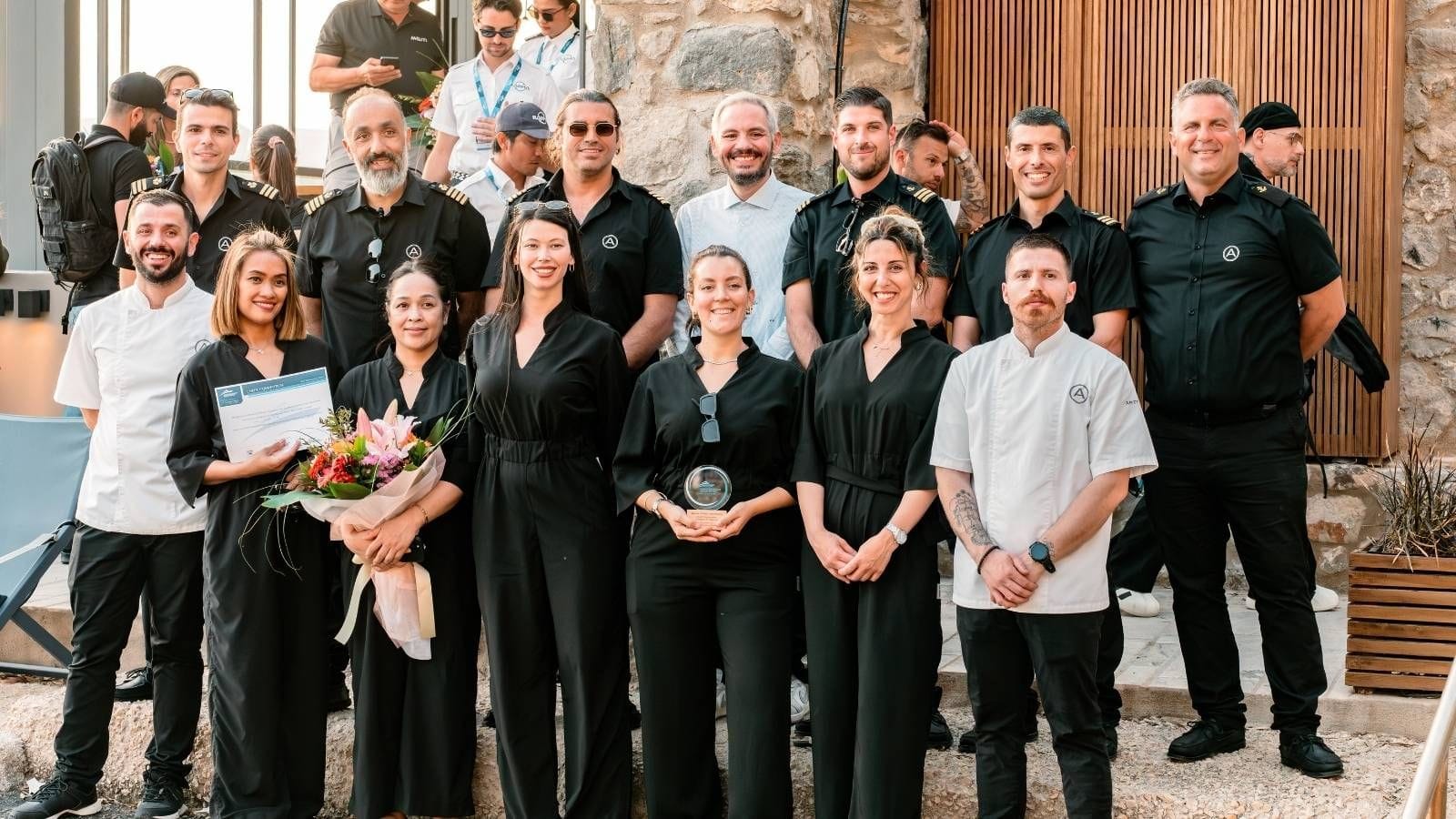 the crew of an iyc yacht celebrating their award at medys greece