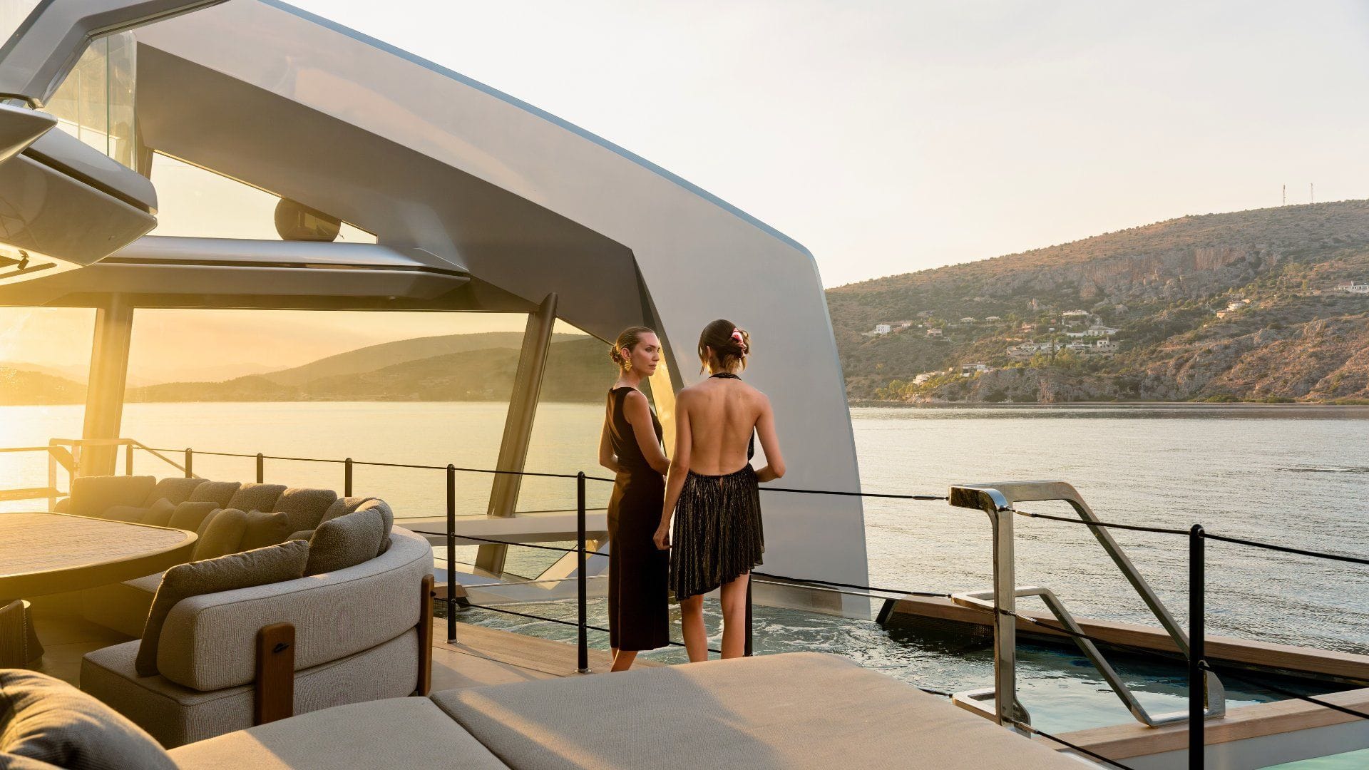 two women discussing on the deck of iyc yacht this is it during sunset in greece