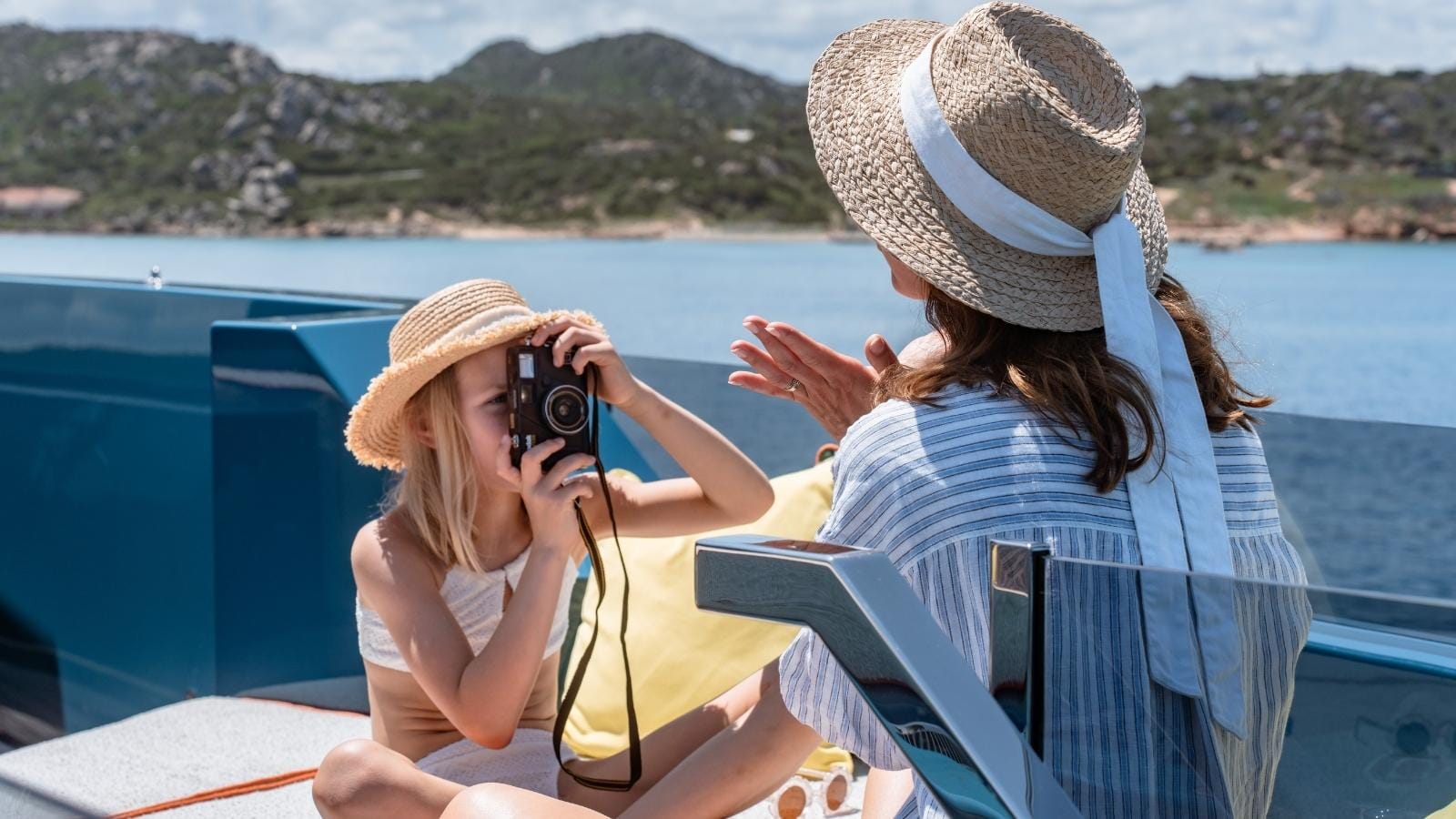 a girl takes a picture of her mother on an iyc yacht