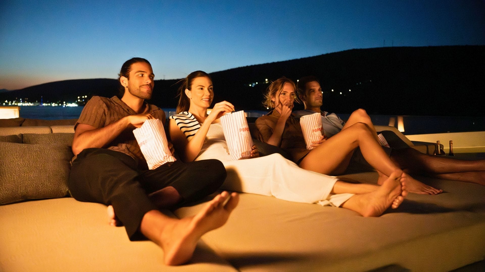 a group of four watching the world cup on the deck of iyc yacht this is it during a summer night