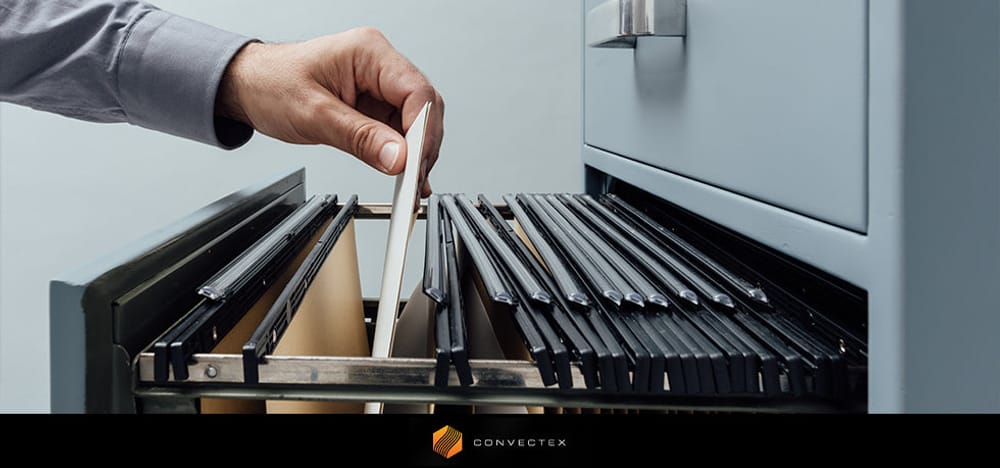 Hand placing a document into a filing cabinet, emphasizing office organization and potential bed bug hiding spots, with Convectex branding visible.