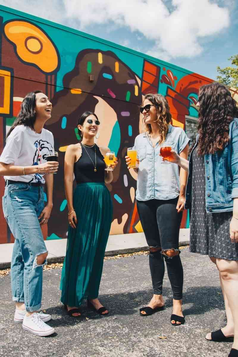 Group of friends enjoying drinks together, exploring a vibrant neighborhood.