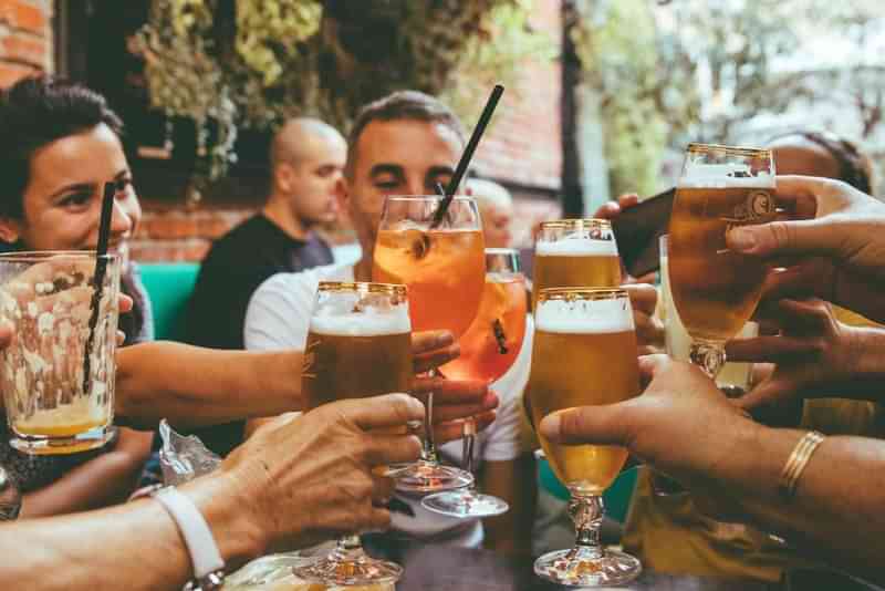 People enjoying drinks and socializing in a lively outdoor setting.