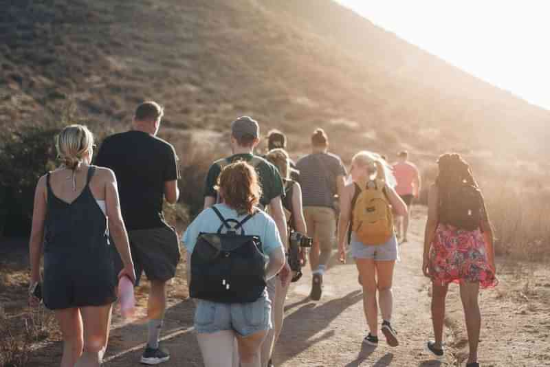 Groep mensen wandelen in natuur voor taal- en cultuuruitwisseling.