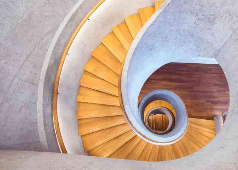 Spiraling staircase in a building, potentially an architectural tour spot.