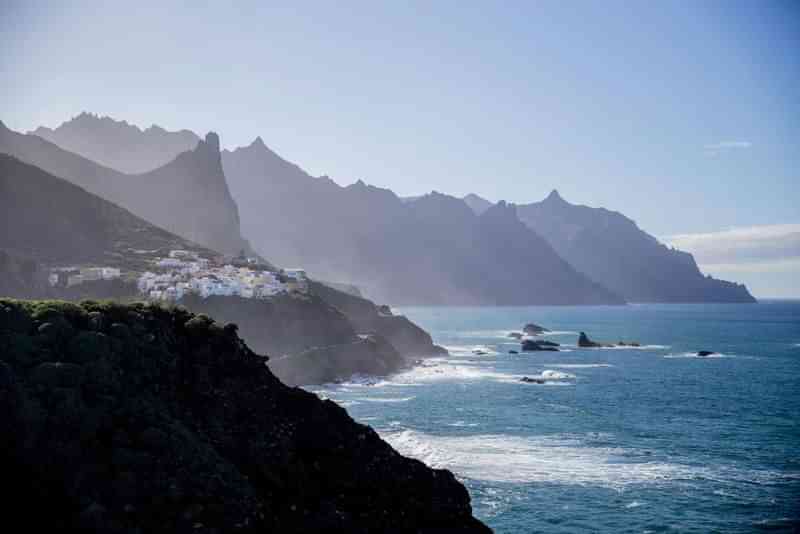 Coastal village, rugged mountains, dramatic scenery, ideal for language immersion travel.