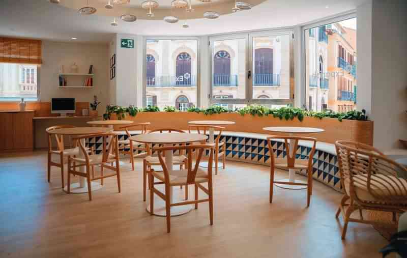 Cafe lounge in language school overlooking historic cityscape, Spain.