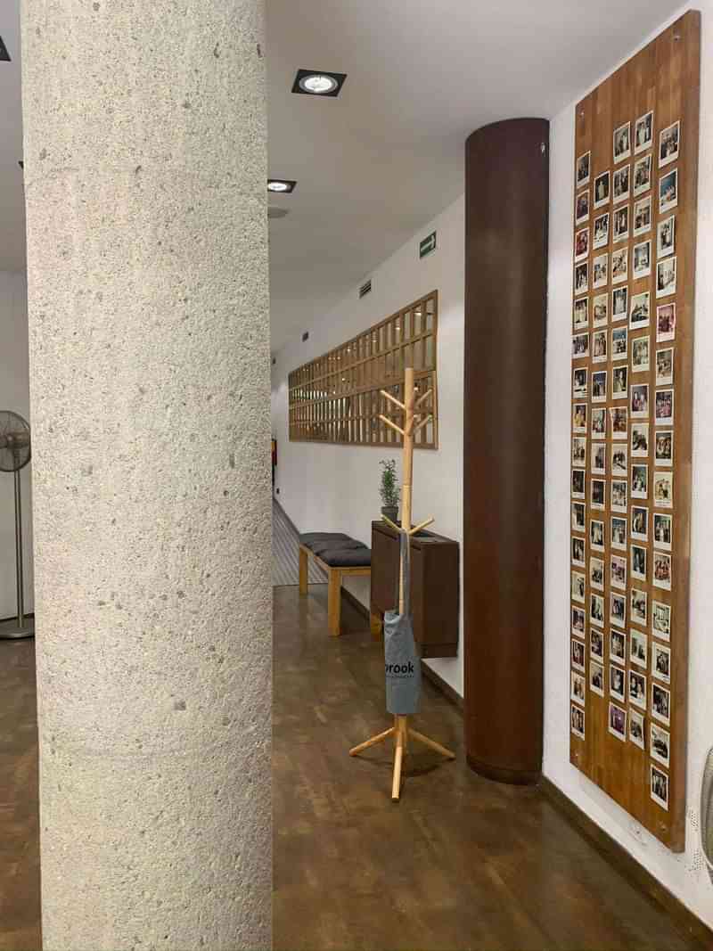 Language school hallway with photo wall and a bench.