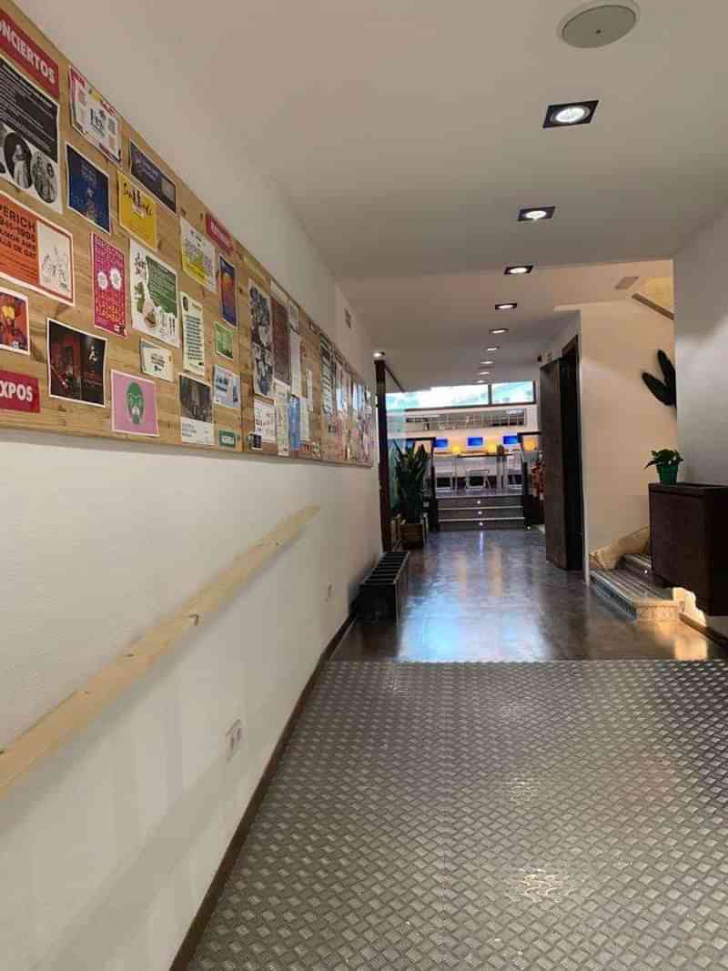 Language school corridor with notice board, seating area, and staircase.