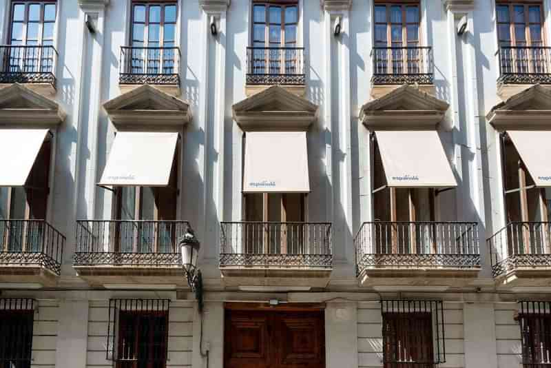 Spanish language school building with balconies and awnings.