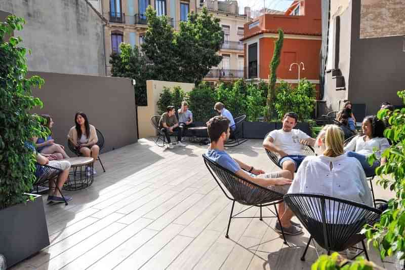 Students socializing outdoors, likely taking a break from language learning classes.