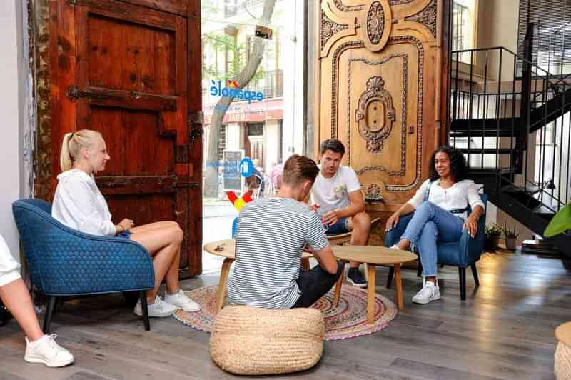 Mensen genieten van een gesprek in een hostel lounge.