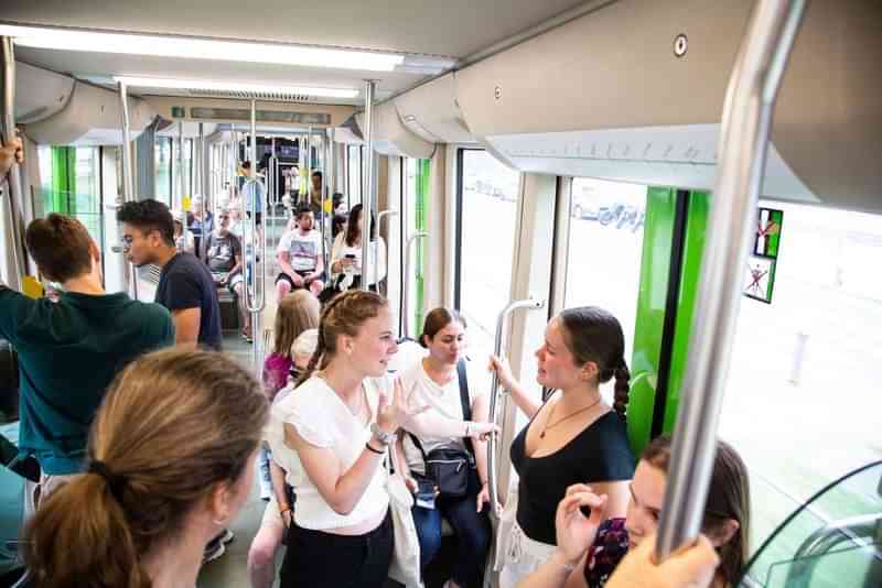 Reizigers in gesprek in de tram. Sociale interactie tijdens het reizen.