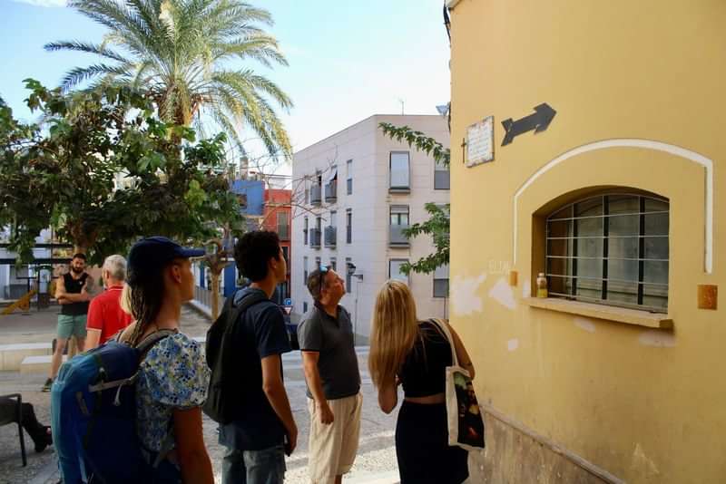 Groep toeristen bestudeert aanwijzingen op straat tijdens een stedelijke taaltour.