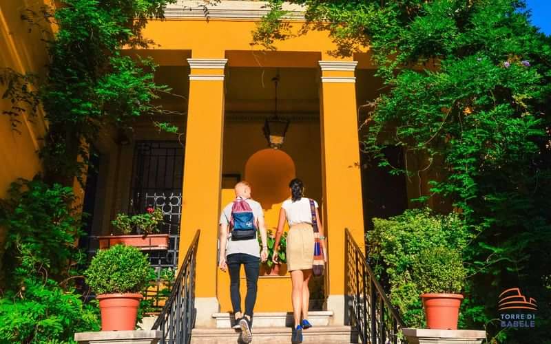 Two travelers entering a vibrant, inviting building for a cultural experience.