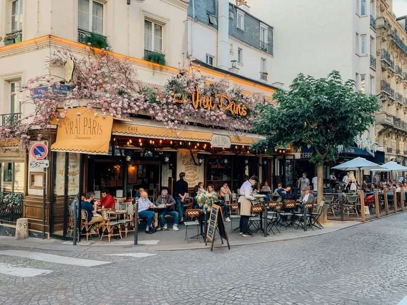 Gezellige hoek in Parijs met café en terras vol mensen.