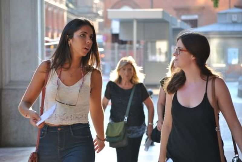 Twee jonge vrouwen praten en wandelen in een stad tijdens een reis.