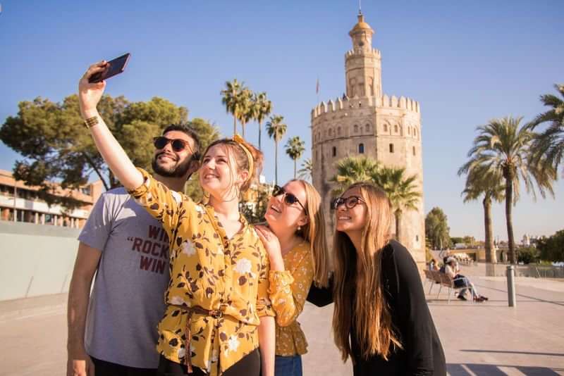 Groep vrienden maakt een selfie voor historische Torre del Oro.