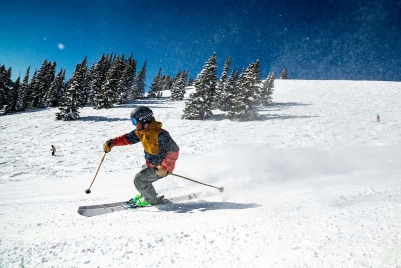 Skiing down a snowy slope at a mountain resort.