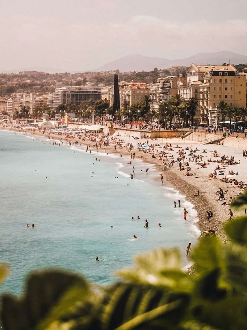 A crowded beachfront in a coastal city, popular language travel destination.