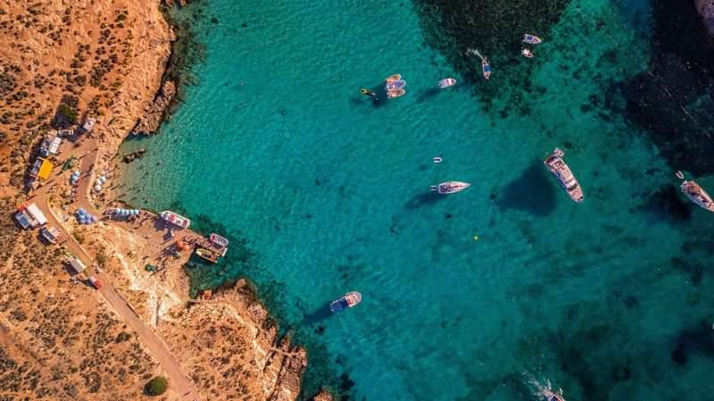 Aerial view: turquoise waters, boats, coastline. Ideal Mediterranean travel destination.