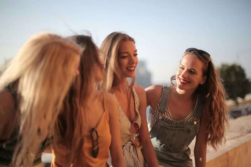 Jonge vrouwen praten en lachen tijdens een reis in de zomer.