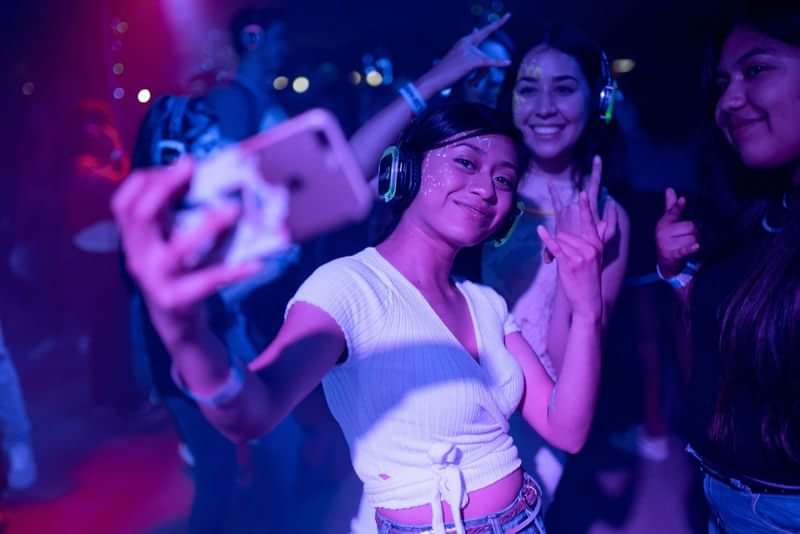 Jonge toeristen maken een selfie tijdens een feestje met koptelefoons.