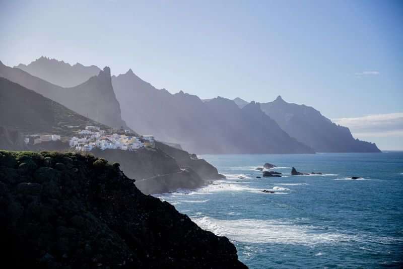 Coastal village, rugged mountains, dramatic scenery, ideal for language immersion travel.