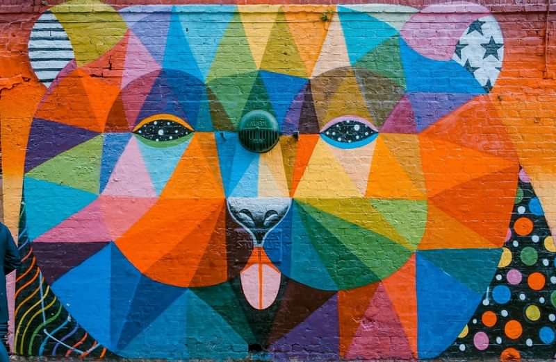 Een kleurrijke muurschildering van een dier in geometrische vormen.