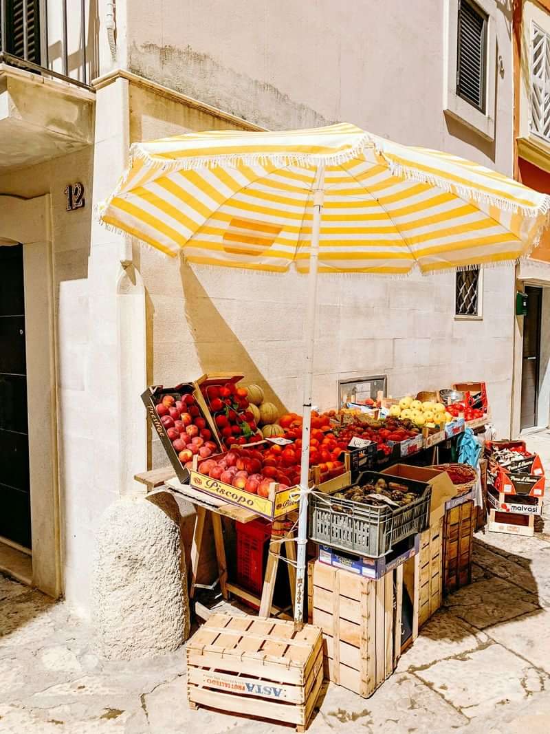 Local fruit market stall on a sunny street corner.