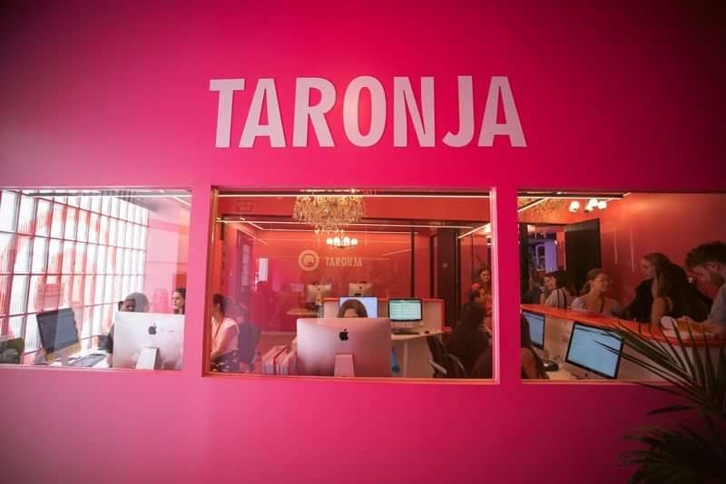 Taronja-taalschool met studenten en computers, waarschijnlijk voor taallessen en reizen.