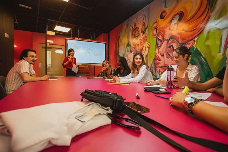 A group of students attending a language class in a vibrant room.