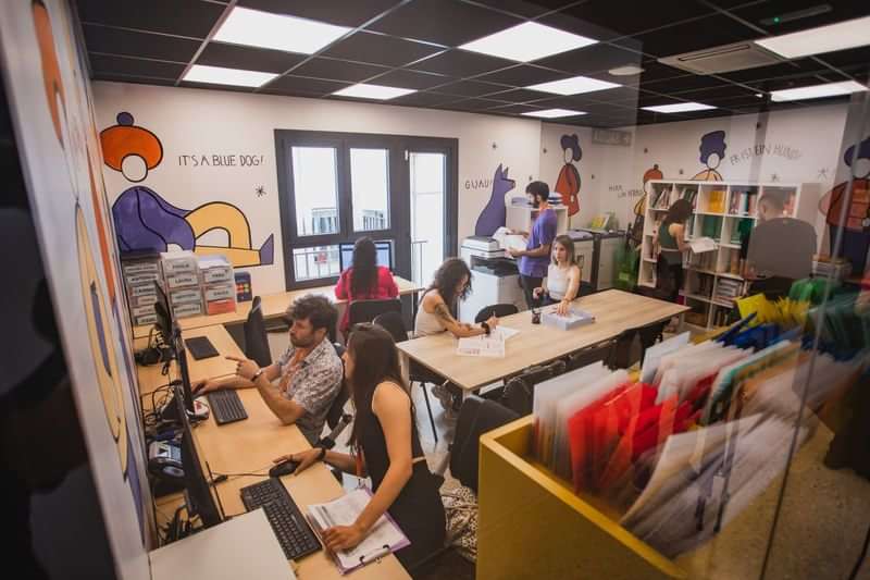 Students working in a vibrant, modern language travel learning center.