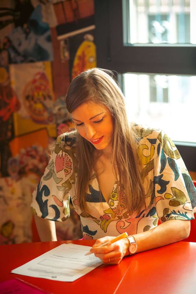 Een vrouw leert een taal in een kleurrijk café omgeving.