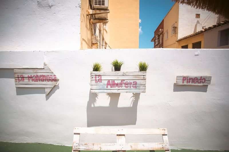 Signs in Spanish pointing to various places within a town.