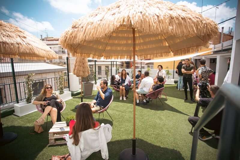 People socializing at a rooftop lounge, possibly part of a language school.
