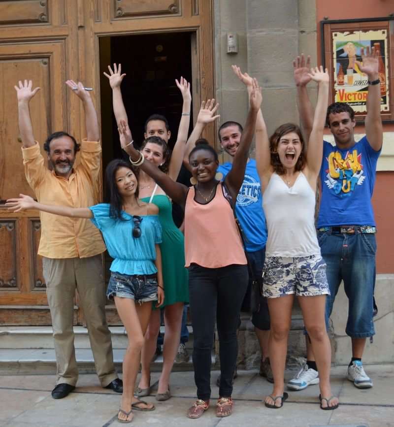 Group of happy international students embracing diverse language travel experiences together.