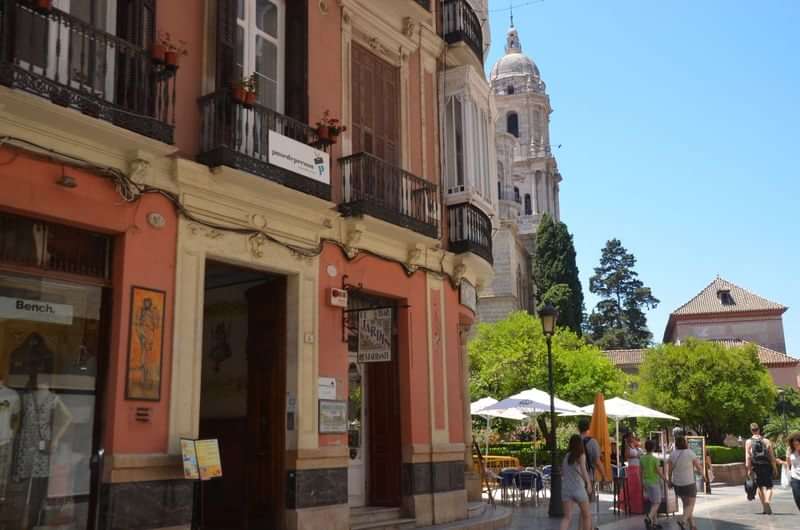 Outdoor scene with historic architecture and people exploring, probably in Spain.
