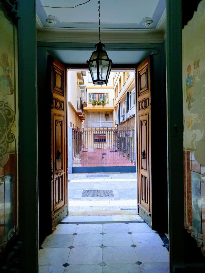 Historic courtyard view through an ornate doorway, inviting cultural exploration.