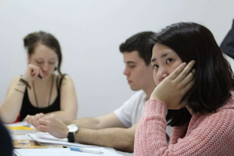 Students participating in a language class abroad, focusing attentively.