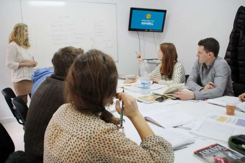 Language students engaging in a classroom lesson, discussing and studying together.