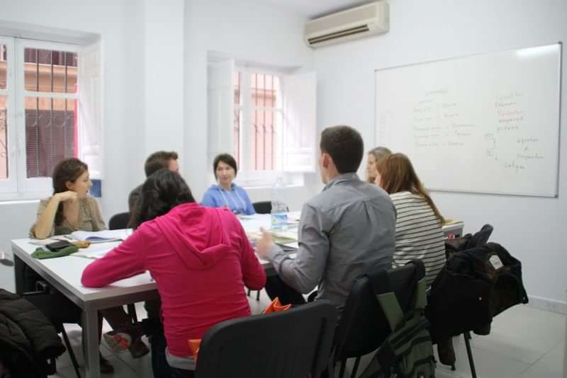 Students in classroom, learning language, whiteboard notes, language travel program.