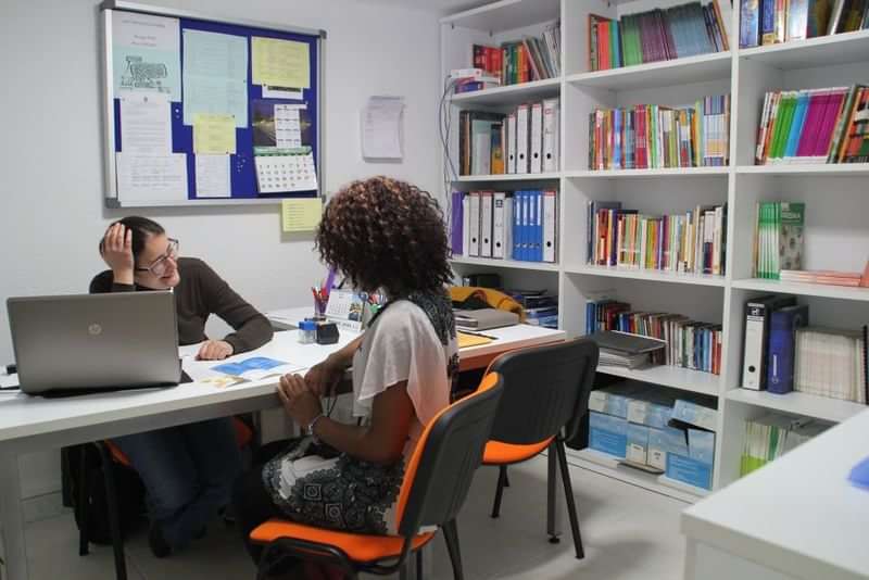 Student and teacher discussing in a language school office.