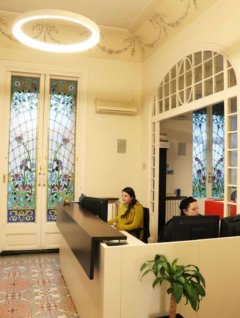Reception area in a language school with stained glass windows.