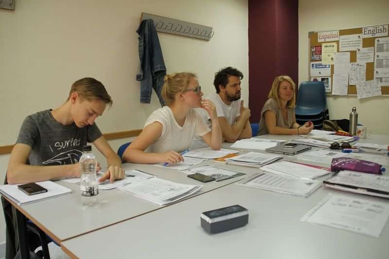 Students in a classroom studying language materials, possibly language school abroad.